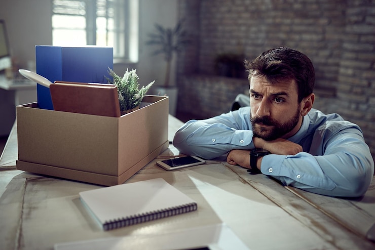 Free Photo young businessman feeling worried about losing his job and thinking of something in the office