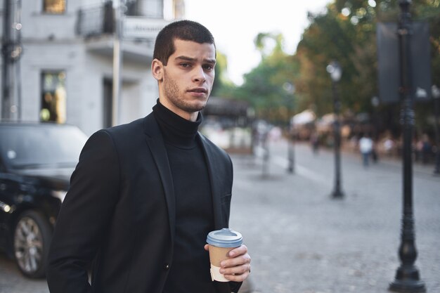 Young businessman going to the work with coffee