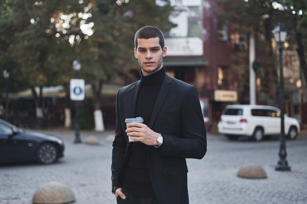 Young businessman going to the work with coffee