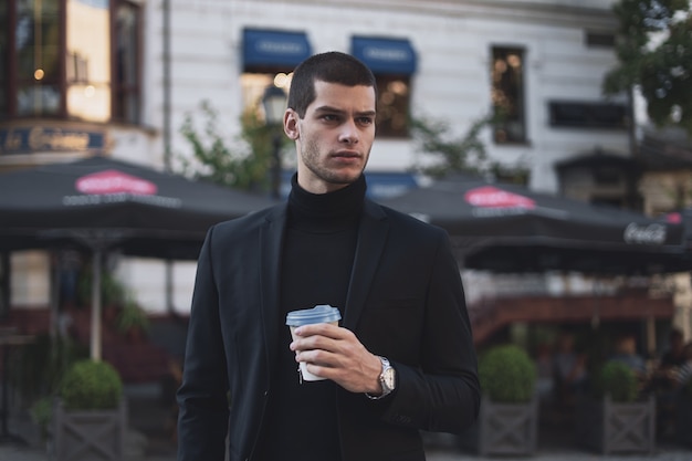 Young businessman going to the work with coffee