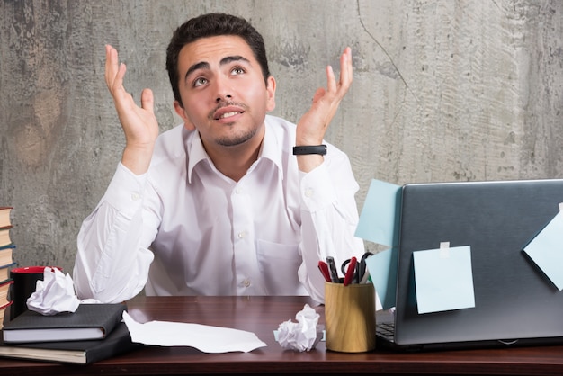 Free photo young businessman having a lot of troubles at the office.