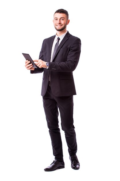 Young businessman holding a digital tablet, isolated on white wall