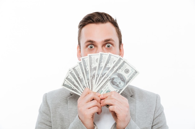 Young businessman holding money covering face.