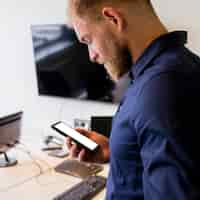 Free photo young businessman looking at blank screen mobile