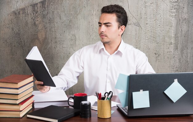 Young businessman looking intensely at notebook at the desk.