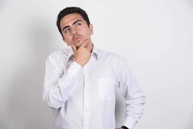 Young businessman looking serious on white background.