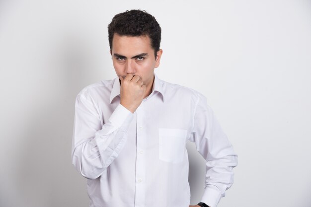 Young businessman looking serious on white background.