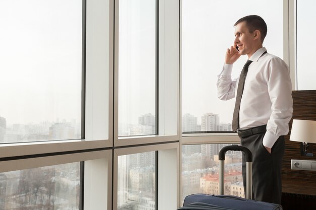 Young businessman making call in hotel room