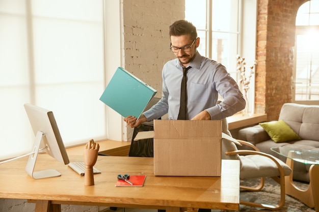 A young businessman moving in the office, getting new work place.