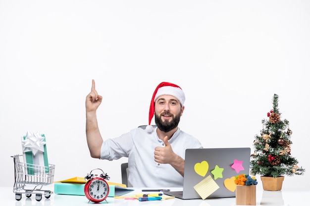 Young businessman in office celebrating and pointing above making perfect gesture