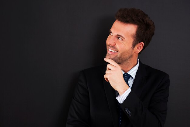 Young businessman peeking at empty blackboard 
