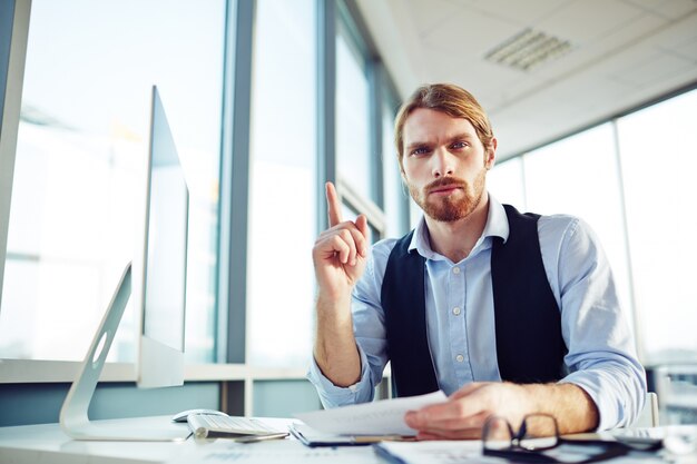 Young businessman pointing up with his finger