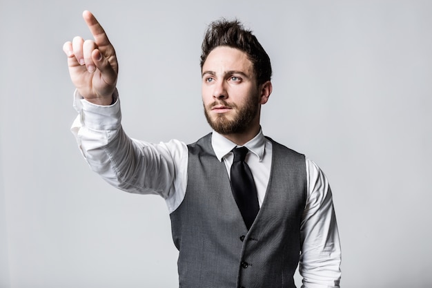 Young businessman pressing a button on an imaginary screen.