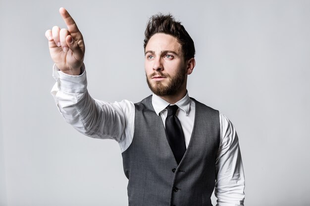 Young businessman pressing a button on an imaginary screen.