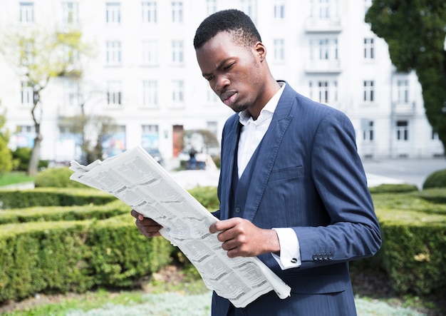 Free photo young businessman reading the newspaper