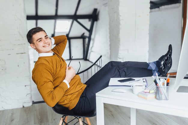 Free photo young businessman resting at his office during break