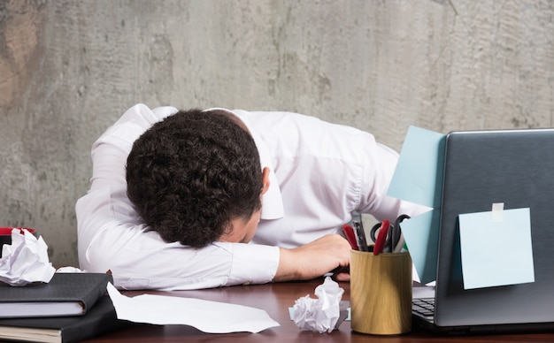 Young businessman sleeping at the office desk.