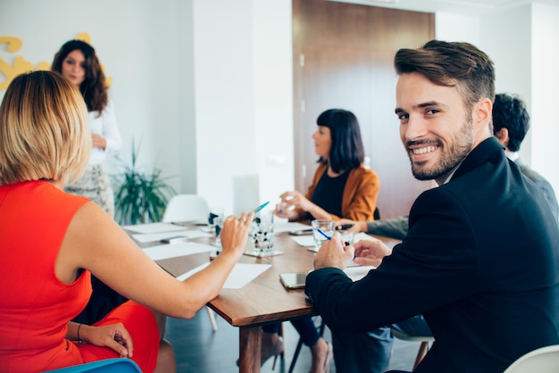 Foto gratuita giovane imprenditore sorridente in occasione della riunione