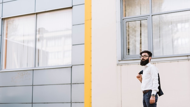 Young businessman standing near the corporate building