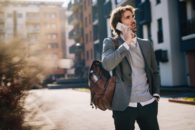 Young businessman talking on cell phone while standing on the street.