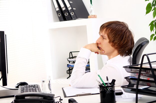 Young businessman thinking in office