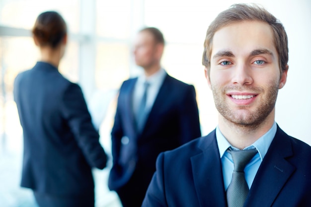 Young businessman with co-workers blurred background