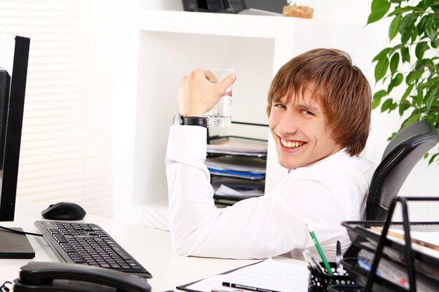 Young businessman with glass of water