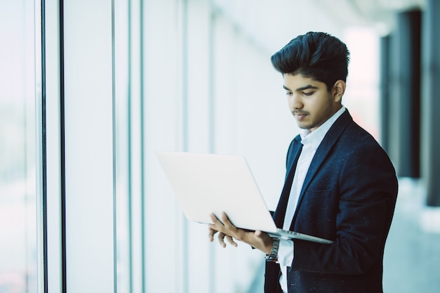 Молодой бизнесмен с ноутбуком, работающих в офисе Бесплатные Фотографии