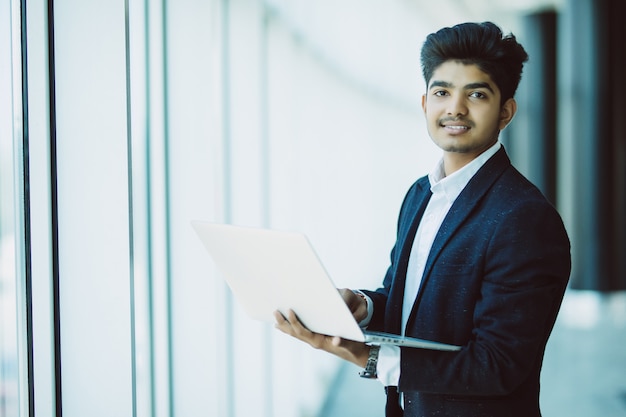 Young businessman with laptop computer working at office