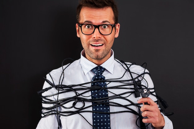 Young businessman with wires around his body