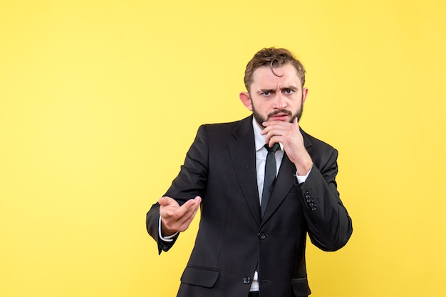 Young businessman wondering with doubt gesture on yellow