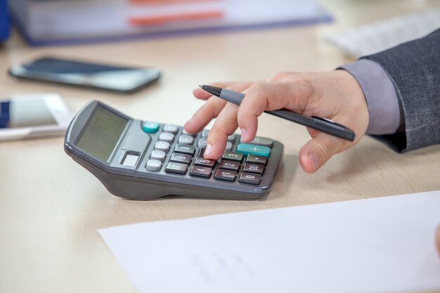 Young businessman working from his office and calculating numbers