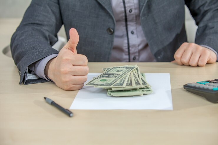 無料Photo 彼のオフィスで働いて現金を数える青年実業家