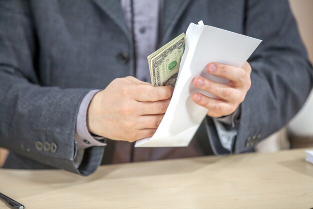 Young businessman working from his office and counting cash money