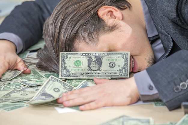 Young businessman working from his office and counting cash money