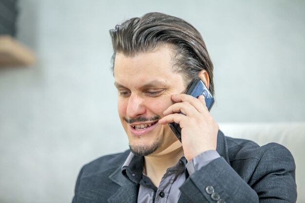 Young businessman working from his office while talking on the phone