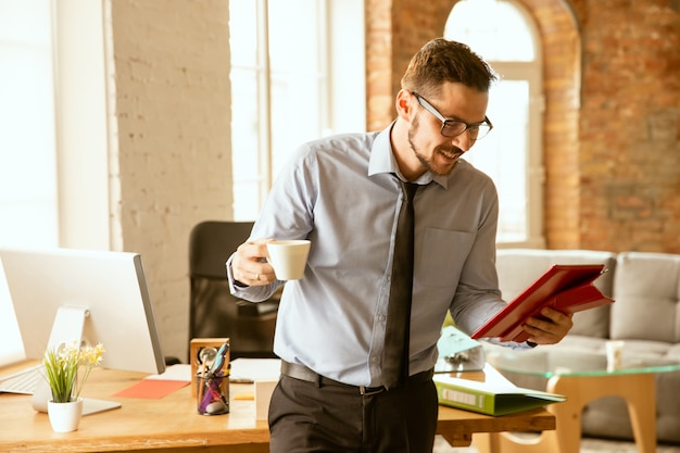 Free photo a young businessman working in office after promotion