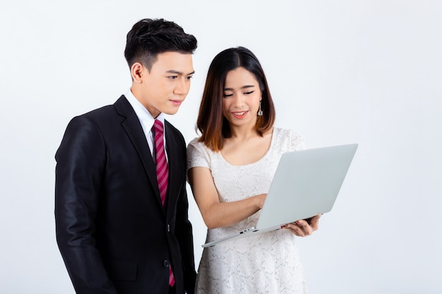 Young businesspeople working with laptop on white 