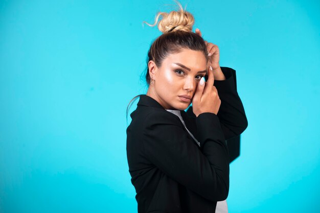 Young businesswoman in black blazer, profile view.