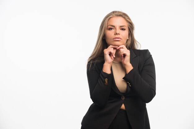 Young businesswoman in black suit looks dedicated.