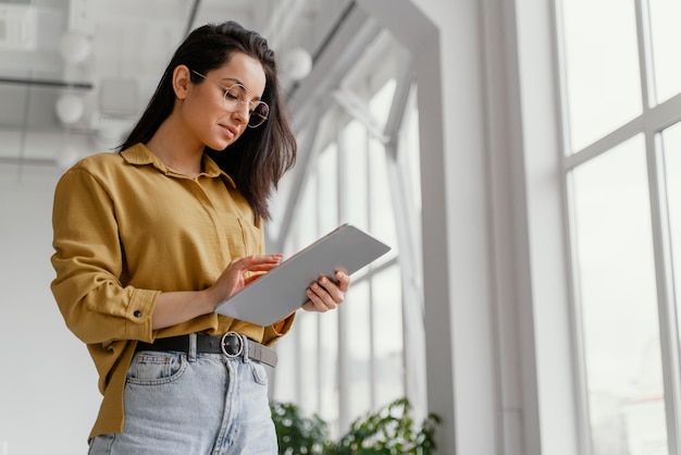 コピースペースで彼女のタブレットをチェックする若い実業家