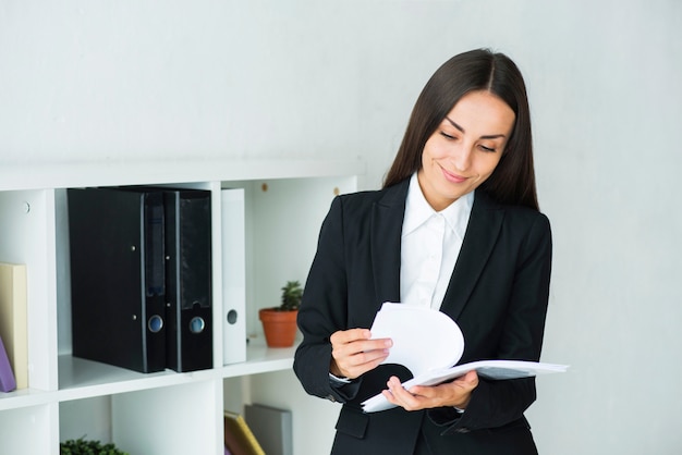 Young businesswoman examining the documents in the office