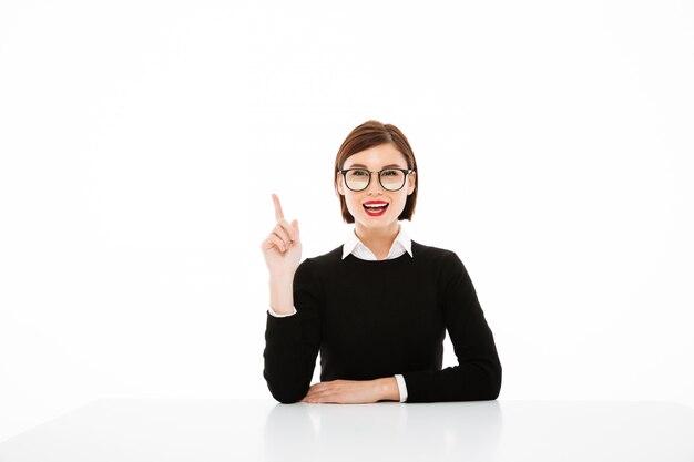 Young businesswoman having an idea, pointing up with finger