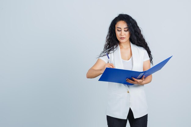 Young businesswoman holding a blue file folder