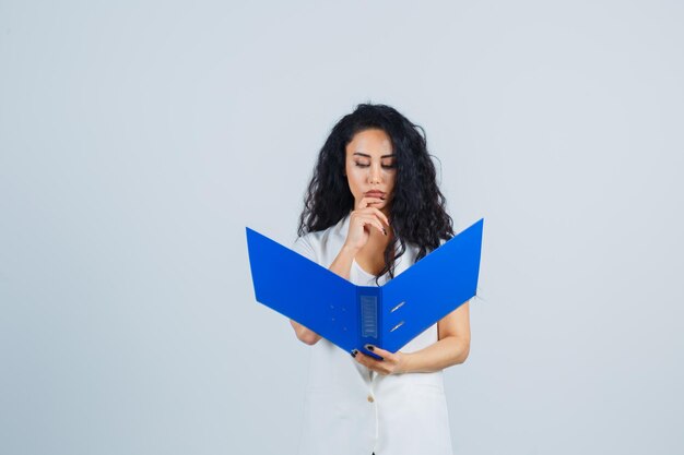 Young businesswoman holding a blue file folder