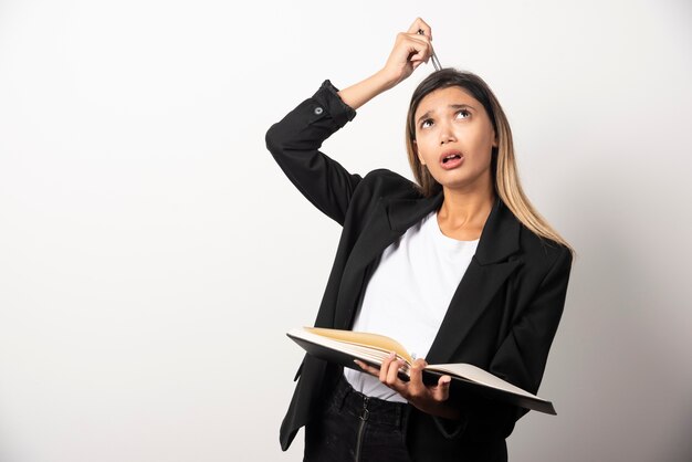 Young businesswoman holding clipboard with pencil . 