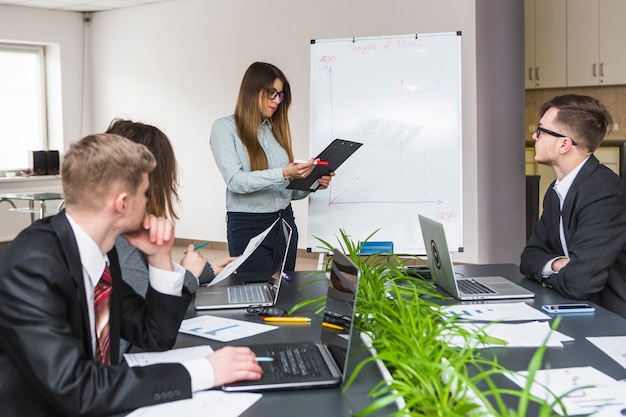 Young businesswoman looking at document in board meeting