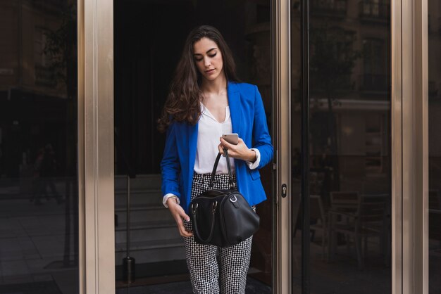 Young businesswoman looking at her handbag