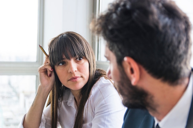 Free photo young businesswoman looking at male colleague in the office