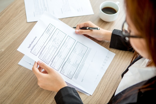 Young businesswoman reading application form